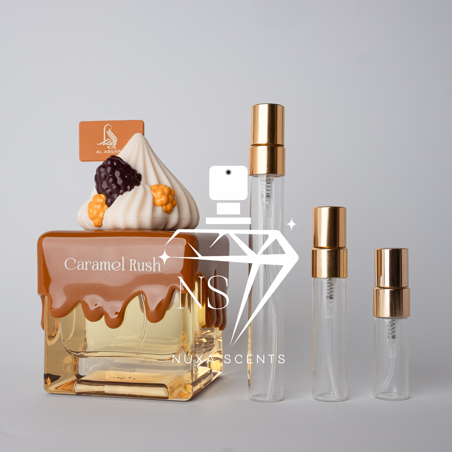 Perfume bottle labeled 'Caramel Rush' by Nuxx Scents with two smaller bottles on a gray background.