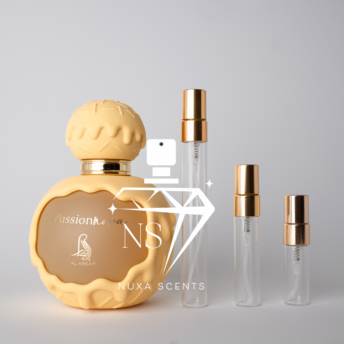 Gold perfume bottle with smaller clear bottles on a gray background, featuring 'Nuxa Scents' branding.
