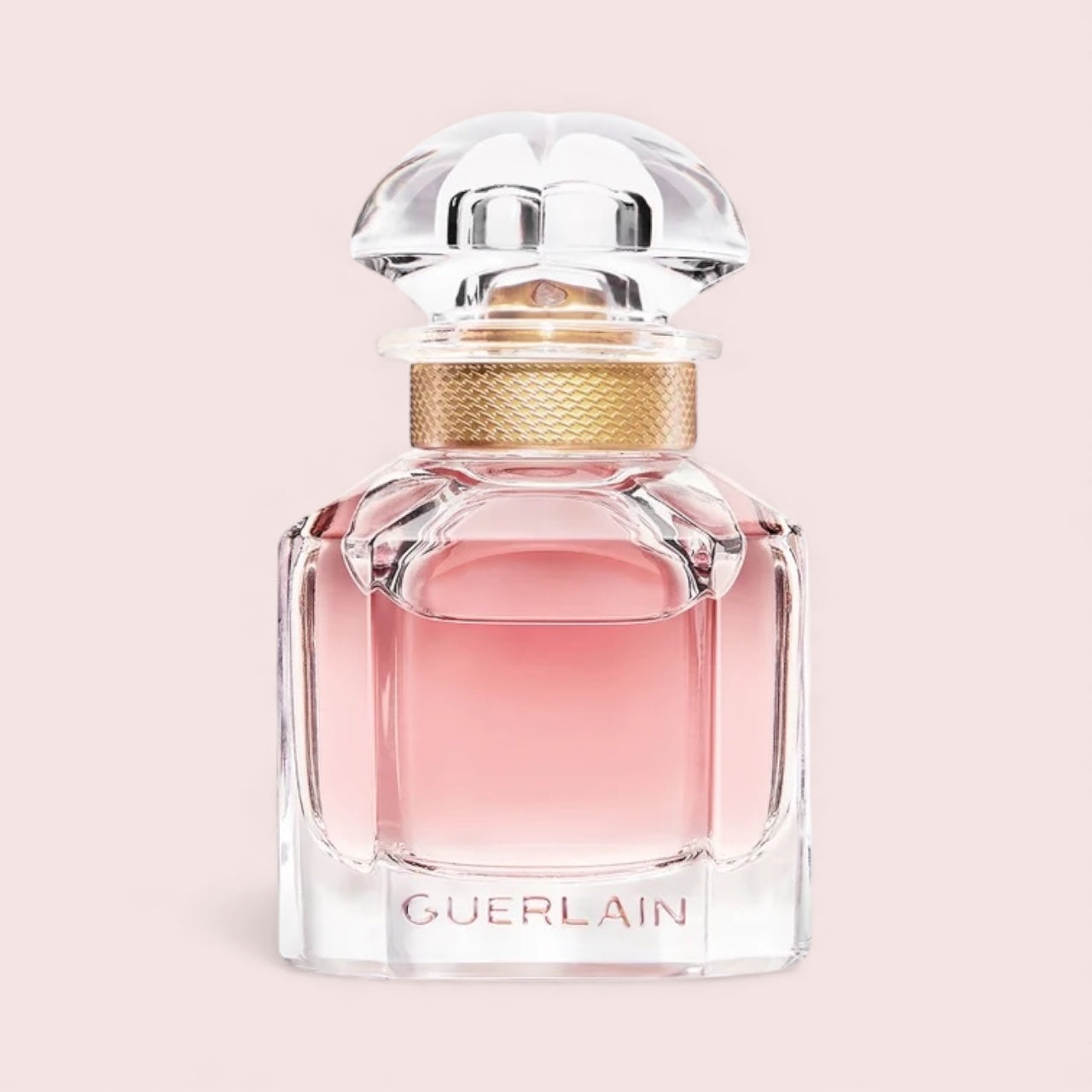 Guerlain perfume bottle on a light pink background