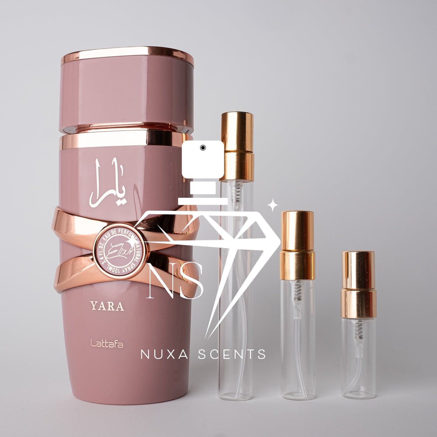 Pink perfume bottle with gold accents and clear bottles labeled 'Nuxa Scents' on a light gray background.