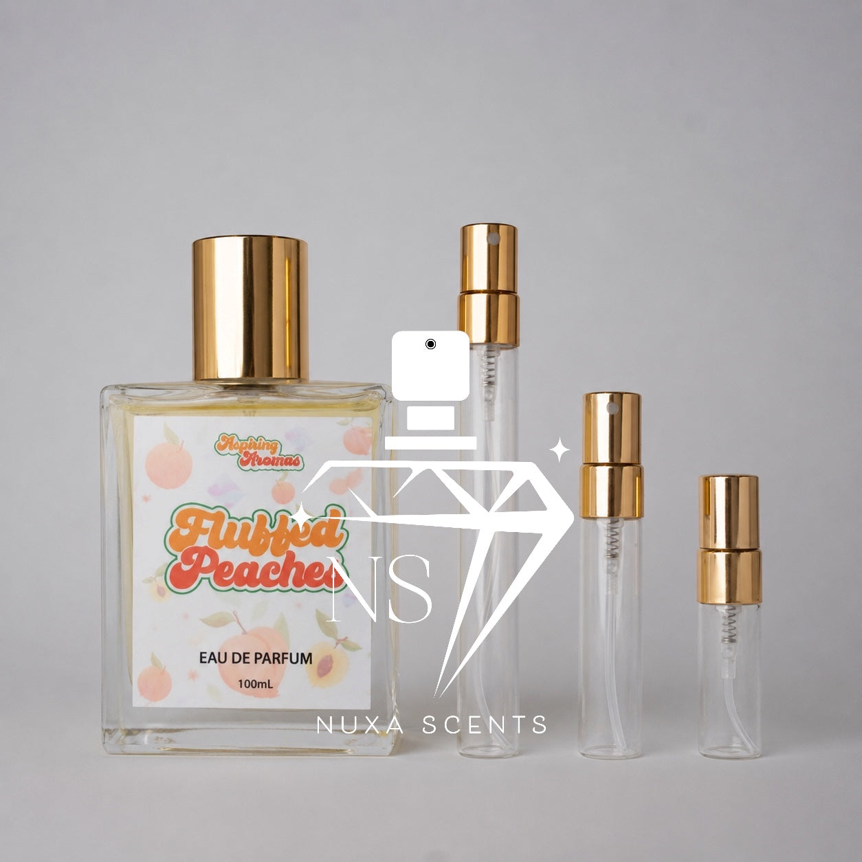 Perfume bottle labeled 'Fluffed Peaches' by Nuxa Scents on a gray background