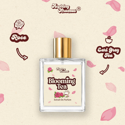 A rectangular glass perfume bottle with a gold cap and a cream-colored label reading 'Blooming Tea Extrait De Parfum', centered on a light beige background with pink rose and tea cup illustrations and the text 'Alofting Aromas'.
