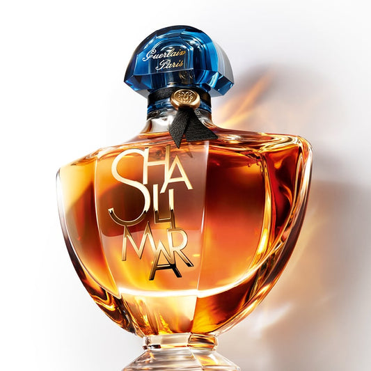 Perfume bottle with blue cap and gold text on a white background