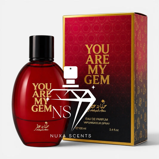 Nuxa Scents 'You Are My Gem' eau de parfum spray bottle and its packaging box. The bottle is a translucent deep red with a black cap, and the box is red with gold lettering and a black gradient base.