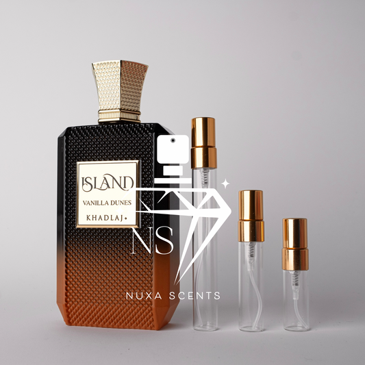 Perfume bottle with gold cap and gradient design, accompanied by smaller clear bottles with gold caps on a gray background.