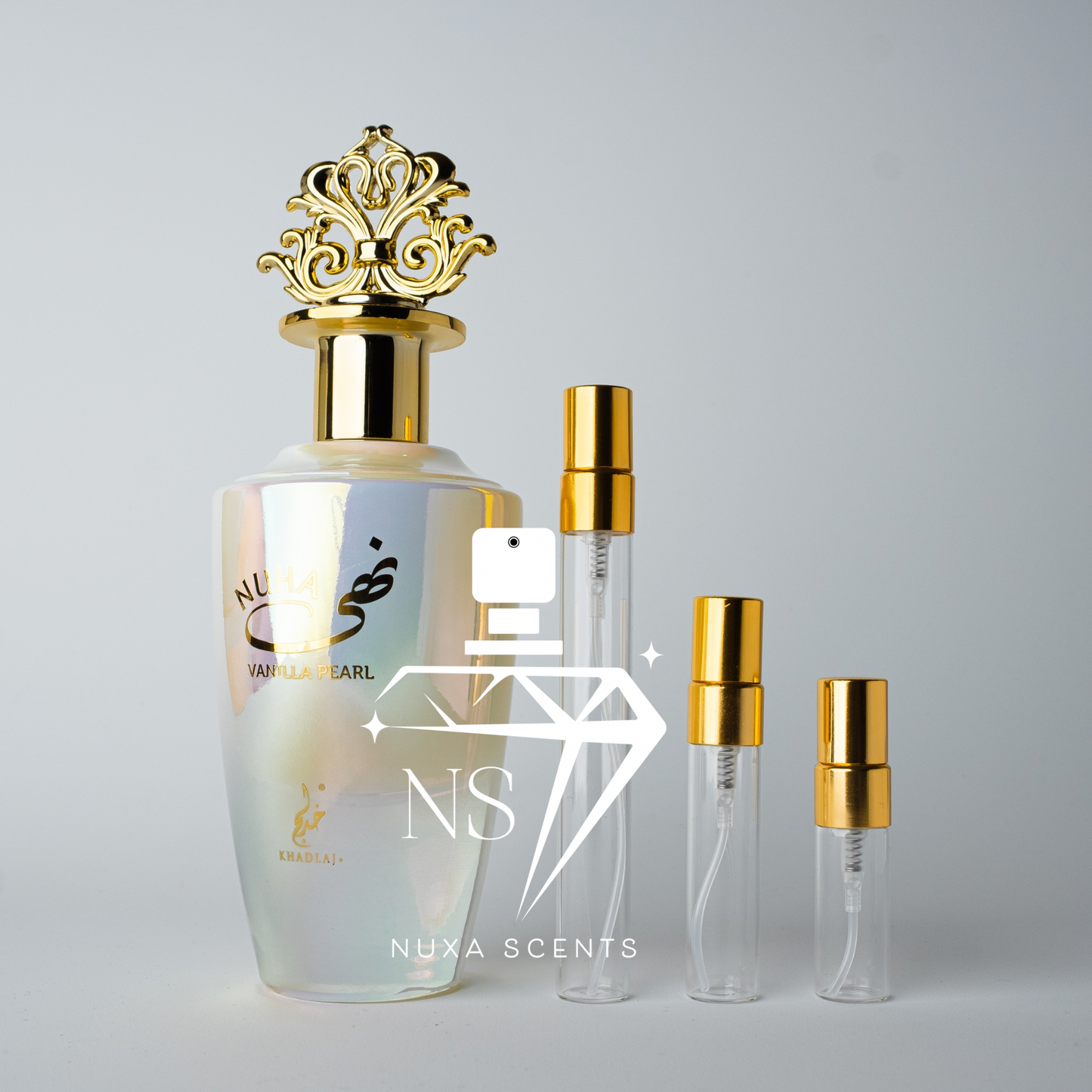 Set of Nuxa Scents perfume bottles with gold caps on a gray background