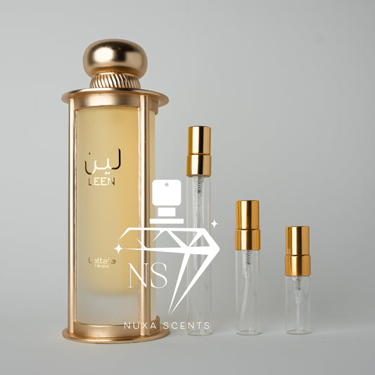 Gold and clear perfume bottles with lattafa branding on a gray background