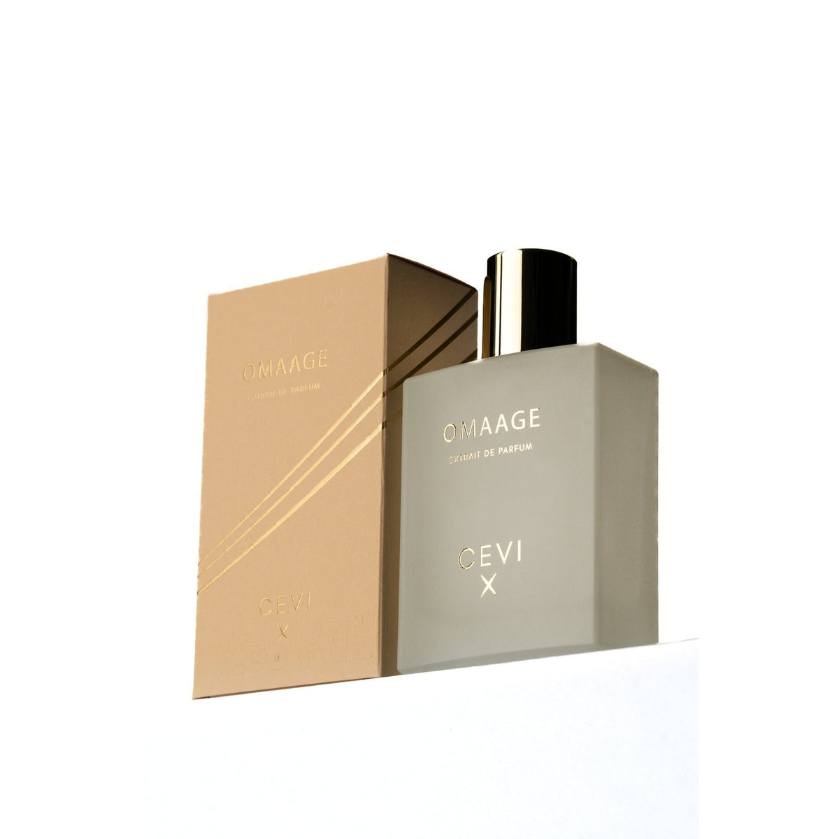 Cevi X Omaage extrait de parfum frosted beige bottle with black and gold cap in front of its tan box with gold stripes