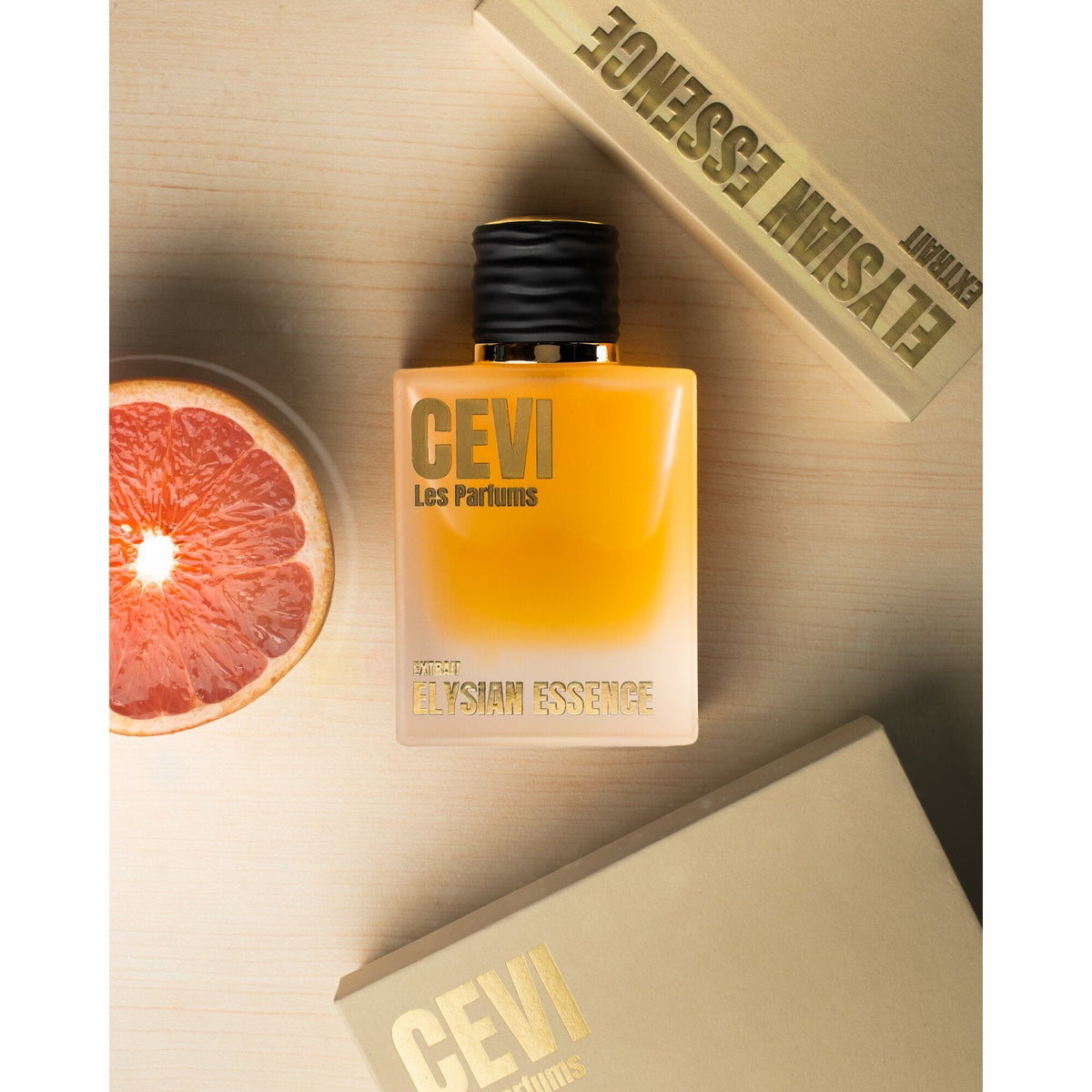 Elysian Essence by Cevi Les Parfums bottle styled with a fresh grapefruit slice and its box