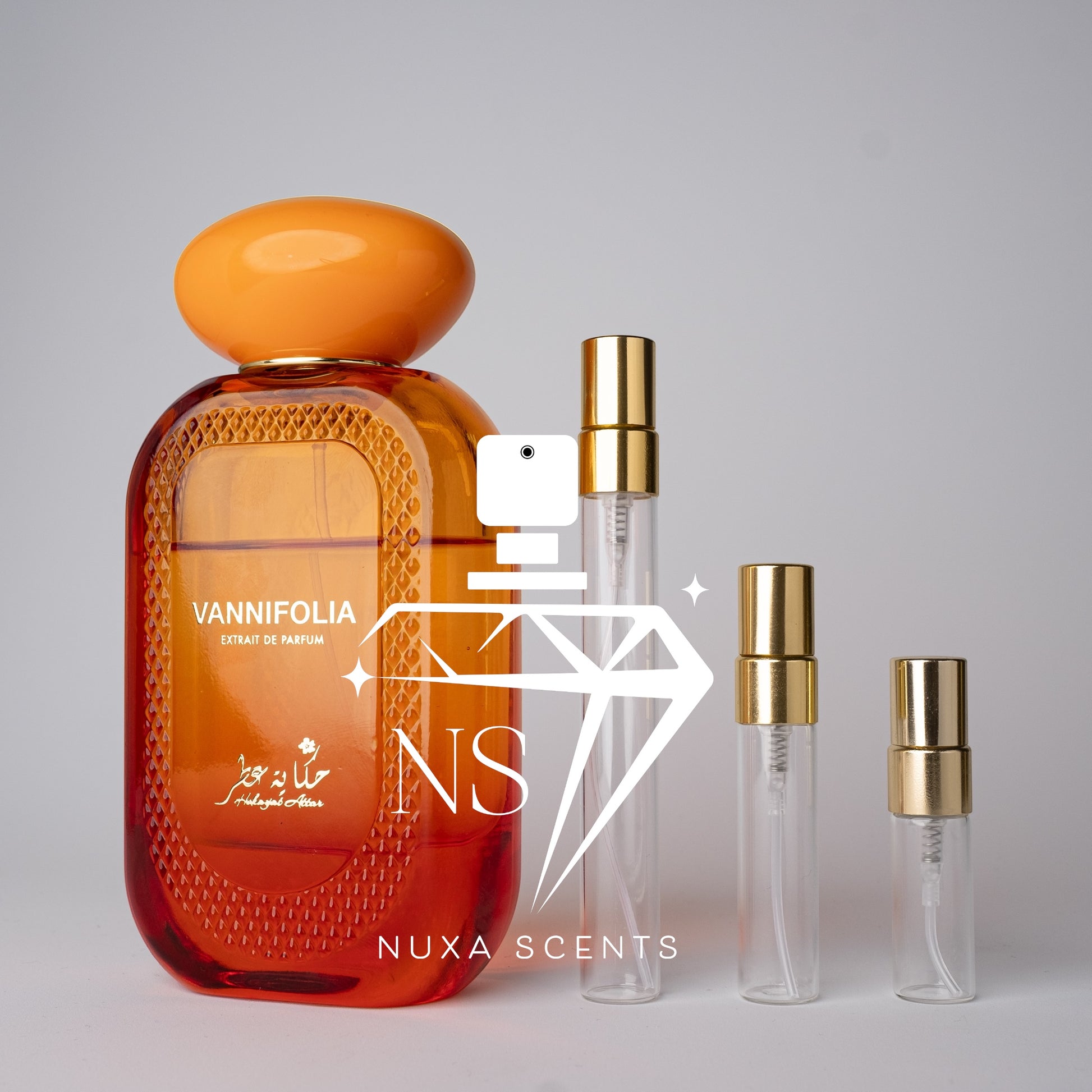 Orange perfume bottle with gold cap and smaller clear bottles on a gray background, featuring Nuxa Scents branding.
