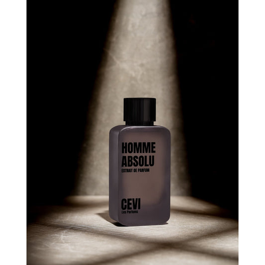 Homme Absolu by Cevi Les Parfums bottle lit by a spotlight on a dark background