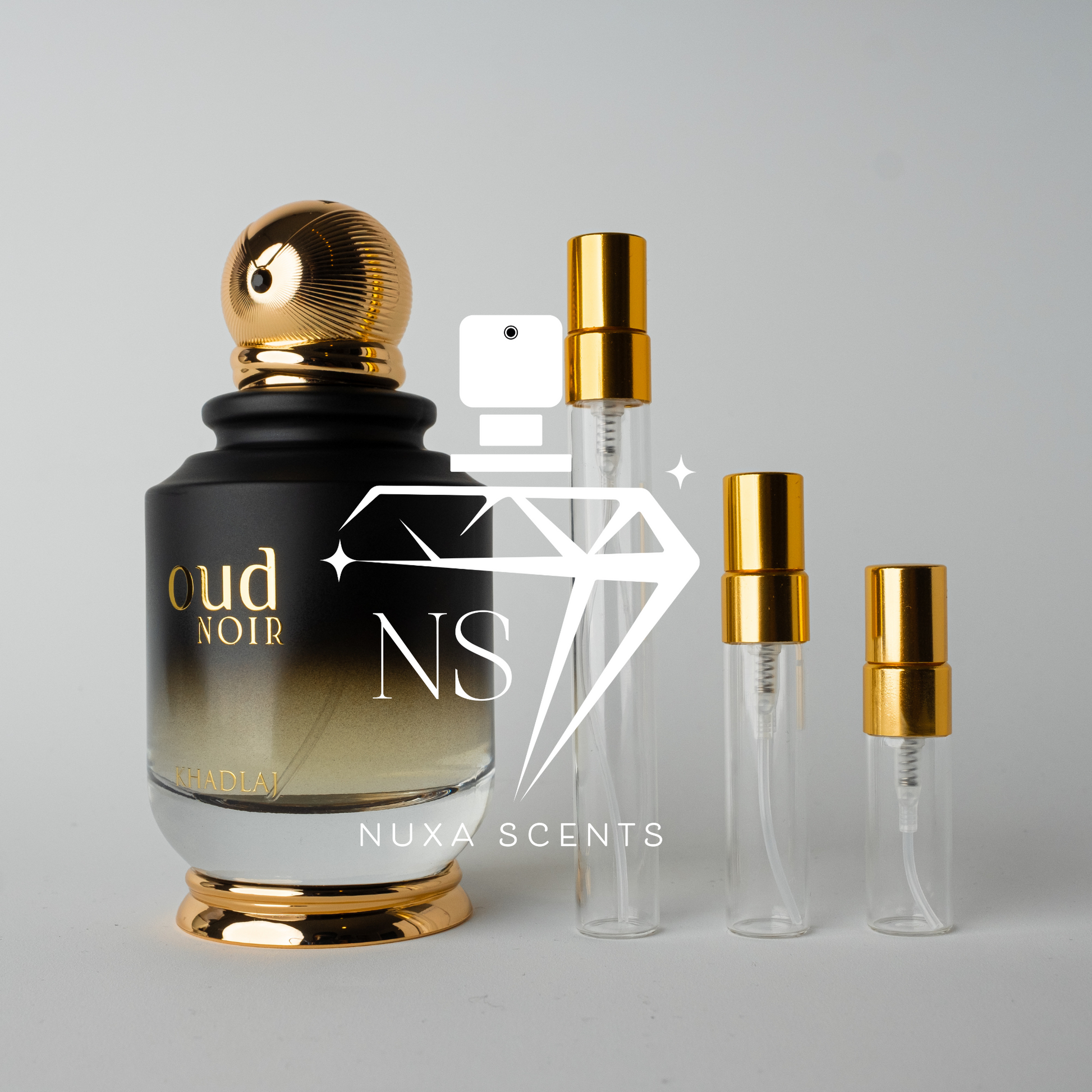 Perfume bottle labeled 'Oud Noir' by Nuxa Scents with gold caps on a gray background