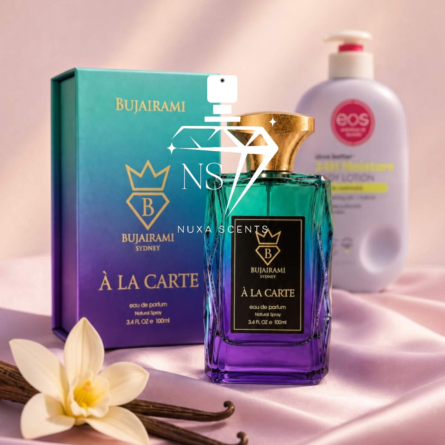 Bujairami 'A La Carte' eau de parfum perfume bottle with a gold cap and purple gradient glass, displayed next to its teal and purple gradient packaging box. A white vanilla flower and vanilla beans are in the foreground, and a bottle of Eos moisturizer is blurred in the background on a pink satin fabric.