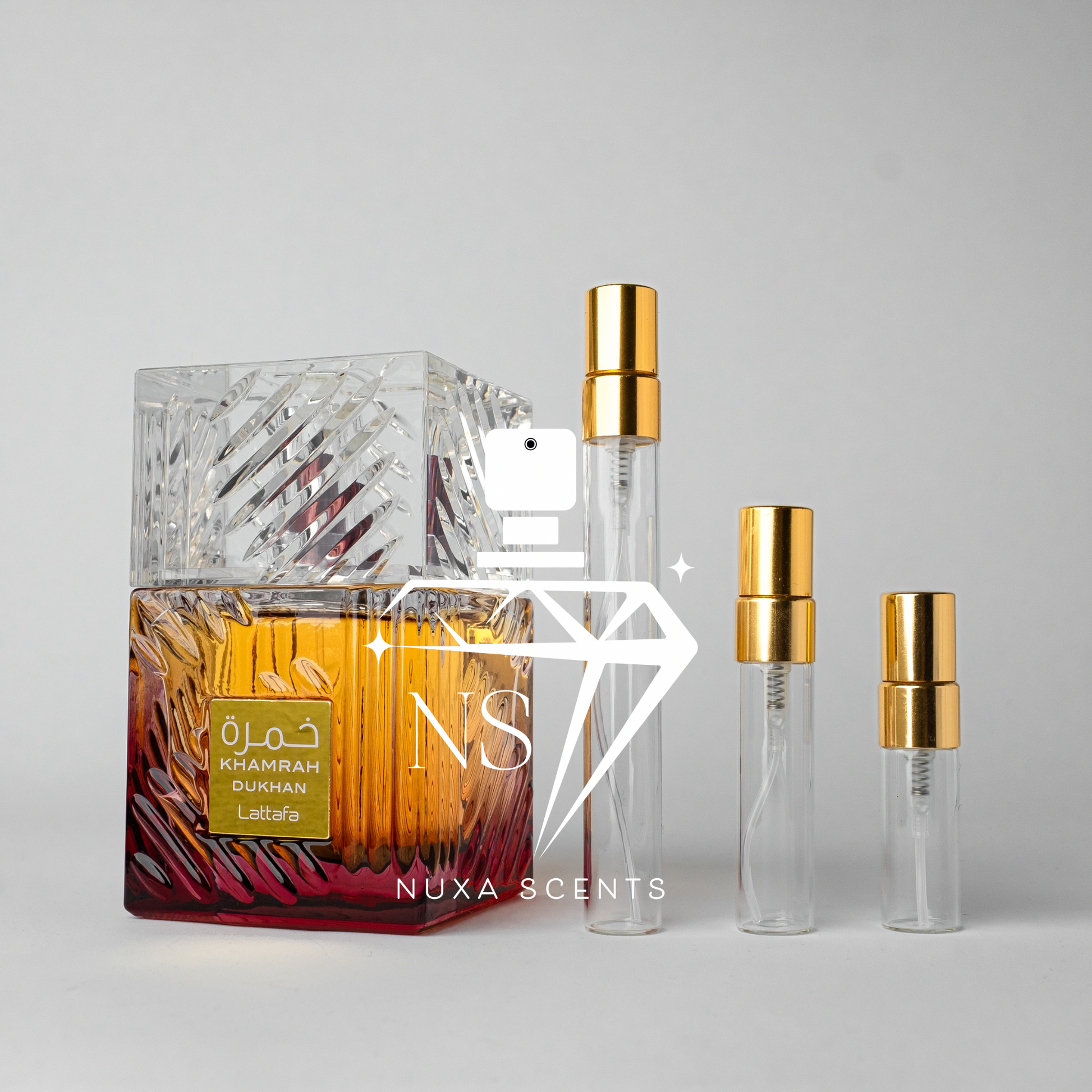 Perfume bottle with gold cap and Nuxa Scents logo on a gray background