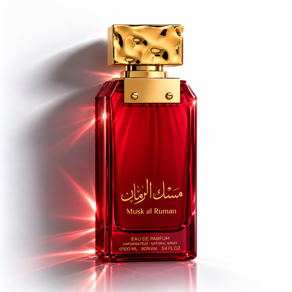 A red glass perfume bottle with a textured gold cap, featuring Arabic calligraphy and the English text 'Musk al Ruman' on the front, set against a white background with dramatic red light flares.