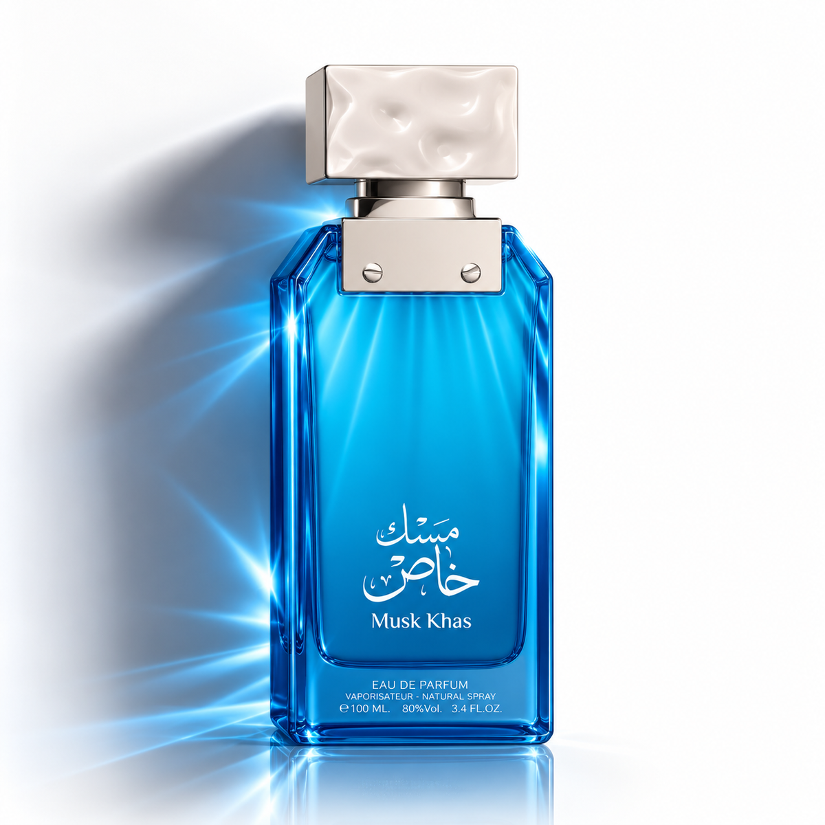 A blue rectangular perfume bottle with a textured silver cap, featuring Arabic calligraphy and the text 'Musk Khas' on the front, set against a white background with dramatic light rays.
