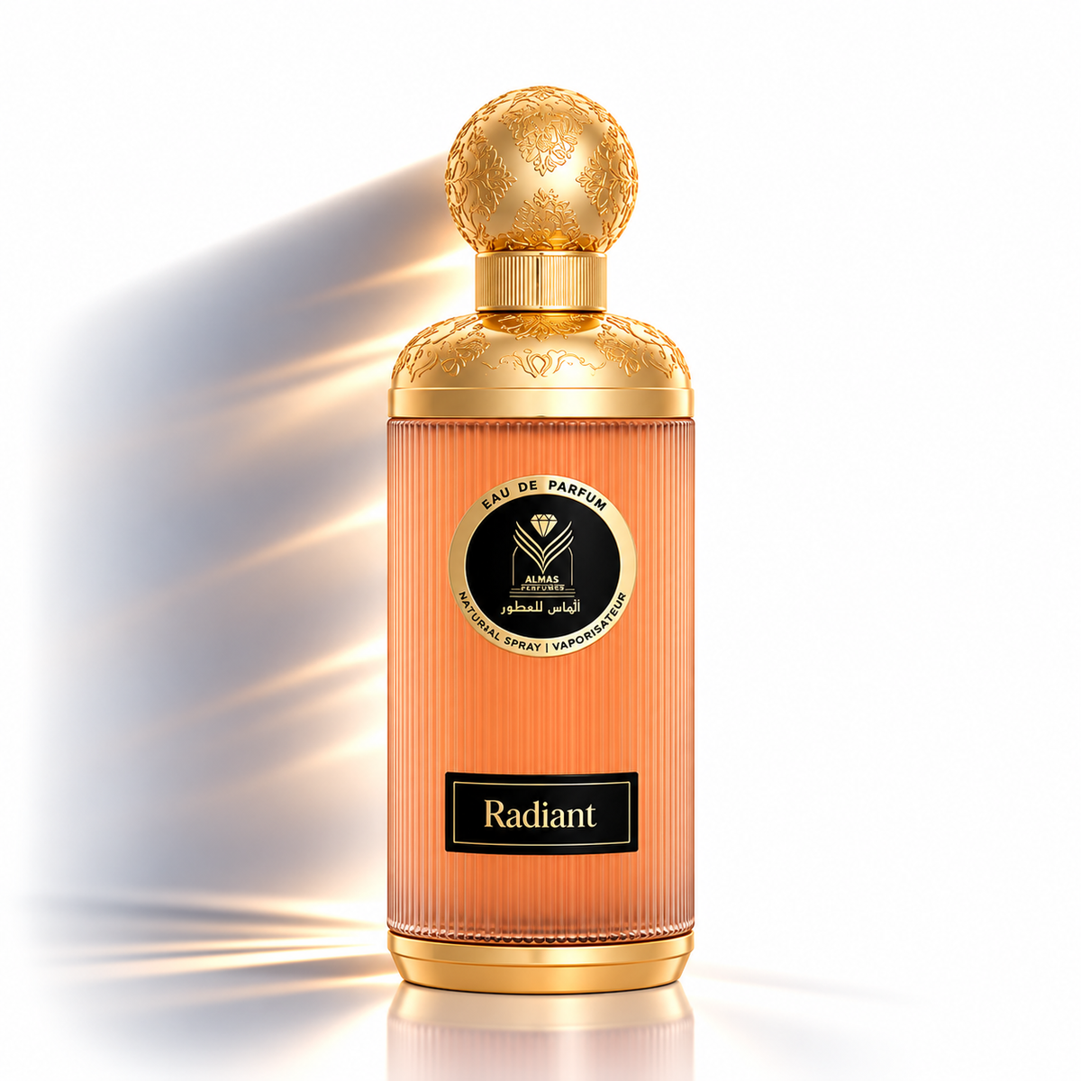 A luxury perfume bottle with a ribbed peach-orange body, a metallic gold cap, and a black label reading 'Radiant' on a clean white background with dramatic light rays.