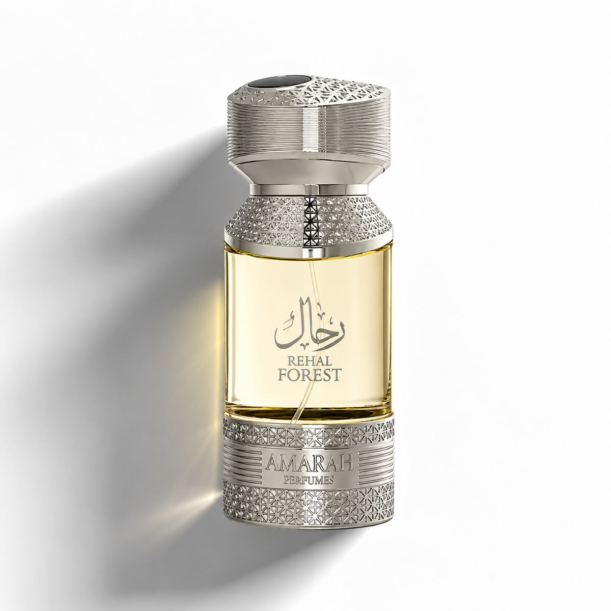 A bottle of Amarah Perfumes Rehal Forest fragrance, featuring a clear glass bottle filled with golden-yellow liquid, adorned with silver-tone metal caps and bases embellished with sparkling rhinestones, set against a clean white background with a soft shadow.