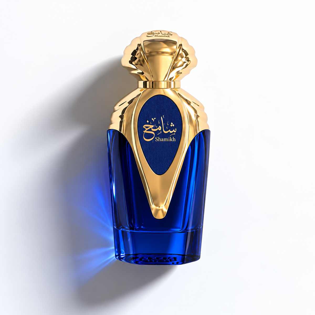 A luxury perfume bottle with a deep cobalt blue glass body and a metallic gold cap and central label. The label features gold Arabic calligraphy and the brand name 'shamkh' in English.