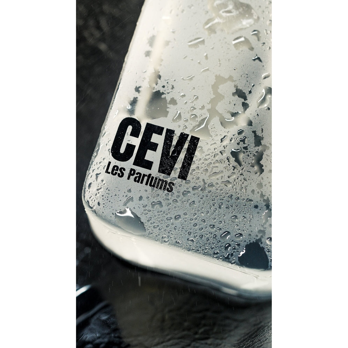 Base of a Sovrin Cevi Les Parfums perfume bottle covered in water droplets on dark wet stone | Nuxa Scents