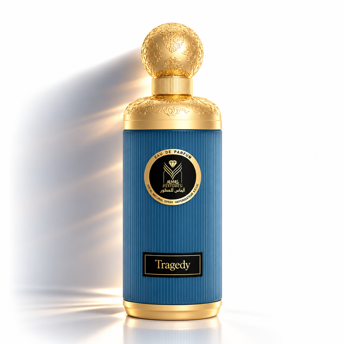 A luxury perfume bottle with a ribbed blue body and ornate gold metallic details, including a spherical cap and a circular label reading 'Tragedy' and 'Eau de Parfum'.