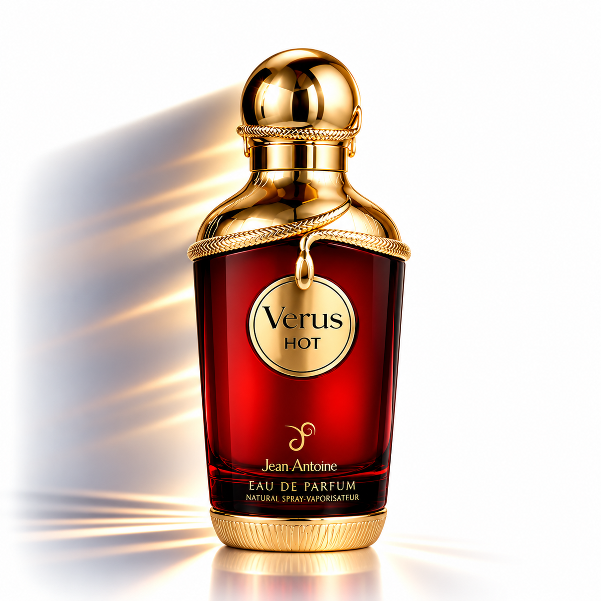 Jean Antoine Verus Hot Eau de Parfum bottle, featuring a deep red glass body with a metallic gold cap and collar, set against a bright white background with dramatic golden light rays.
