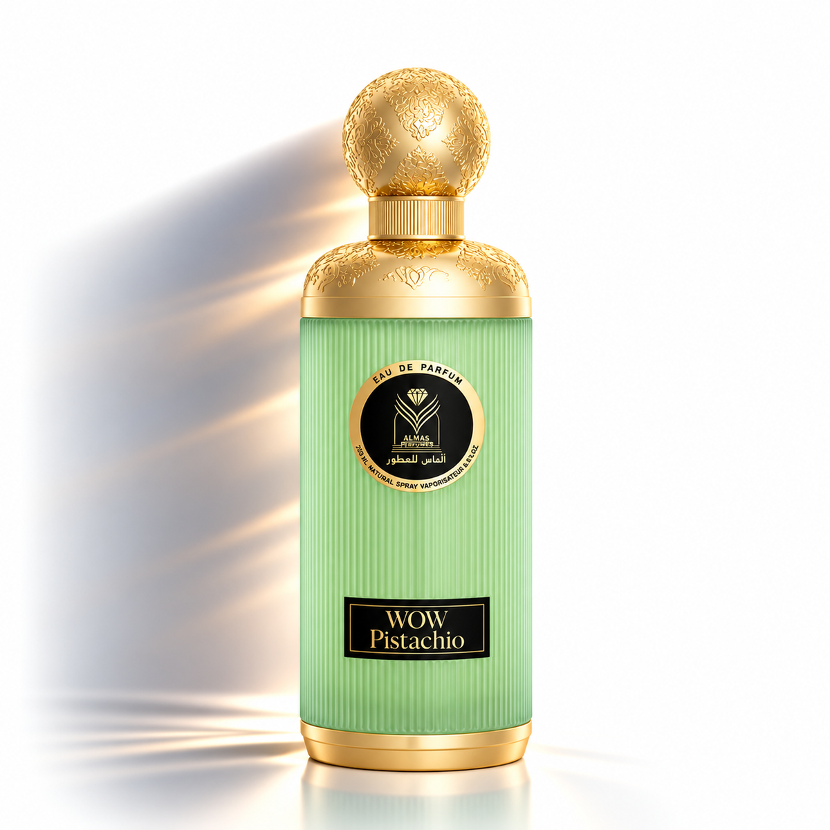 A luxury perfume bottle with a ribbed pistachio green body, gold metallic collar and cap, and a black circular label reading 'WOW Pistachio' and 'Eau de Parfum'.